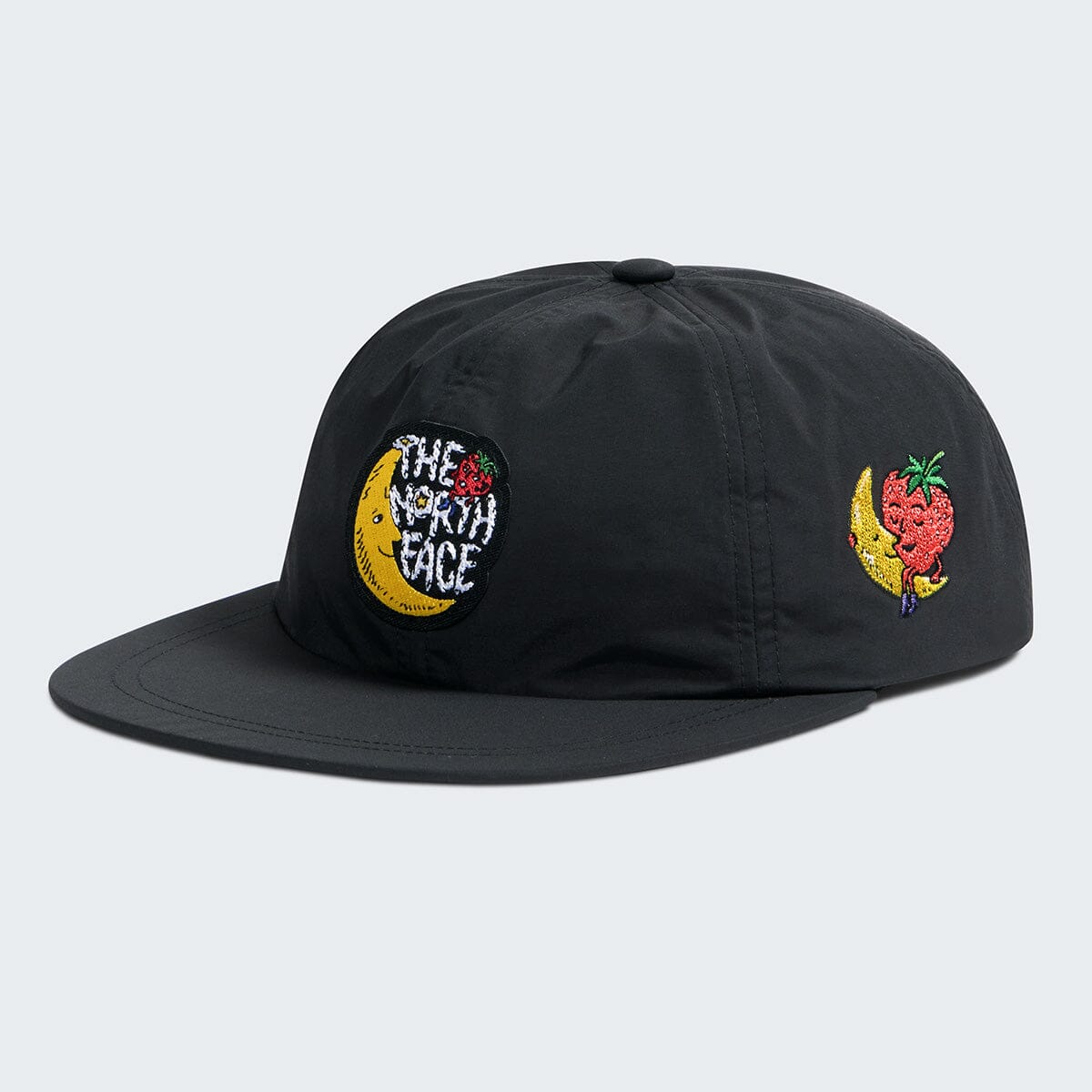 Black cap with embroidered designs on a light gray background