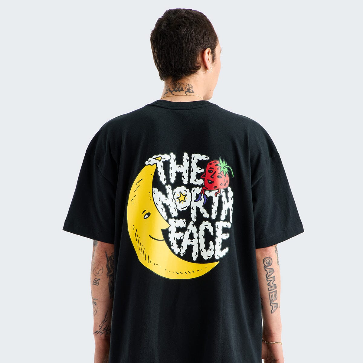 Person wearing a black t-shirt with a colorful graphic and 'The North Face' logo on the back.
