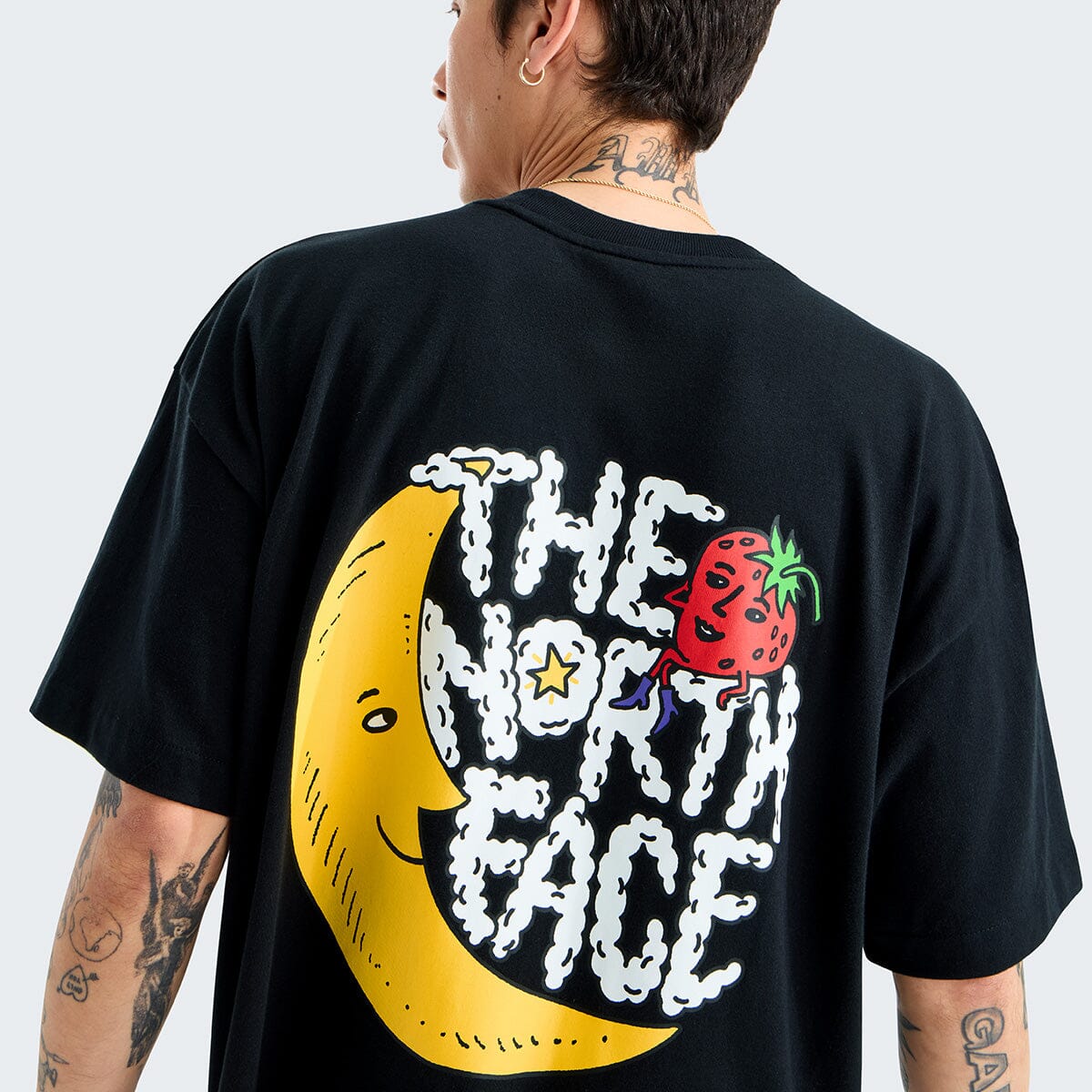 Person wearing a black t-shirt with a colorful graphic design on the back.